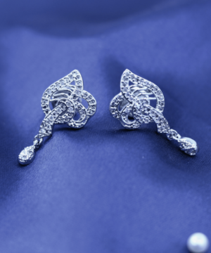 live photography of 925 sterling silver earrings on the blue fabric.